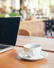 Home Office Desk Concept.Laptop and cup of coffee placed on wooden desk-computer for planner to plan job, working space at home-vertical image.