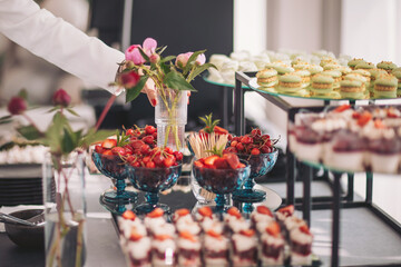 Colorful dessert display showcasing an array of treats and floral arrangements at a festive...
