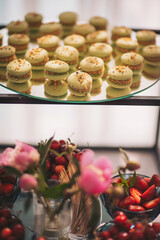 Delightful green macarons and vibrant strawberries arranged elegantly for a sophisticated dessert table at a spring gathering