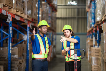 Workers in reflective vests discuss tasks and direct each other while transporting boxes through...