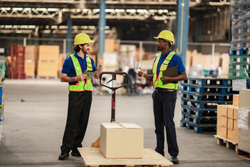 Operational staff push products to the dispatch area while handling work instructions. Worker in warehouse and delivery industry.