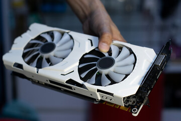 Side of white graphics card, computer parts, technician holding graphics card