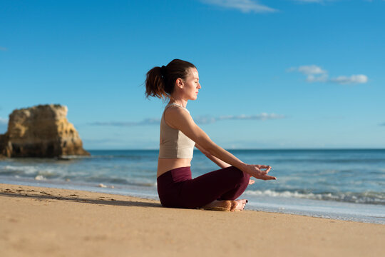 Woman Meditating on a Beach, Peaceful Sunny Day
