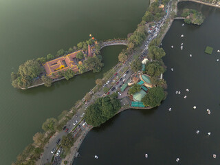 Scenic view of West Lake and surrounding area in Hanoi, Vietnam during a clear day with lively activity and greenery