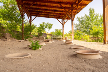 Clay wine vessels embedded in earth beneath wooden shelter at Armaziskhevi site, part of an ancient wine making cellar in Mtskheta region, Georgia