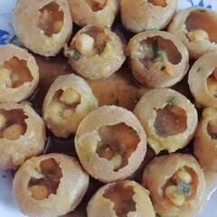 Crispy puris filled with spicy potato stuffing and tangy water, a favorite street snack from India.