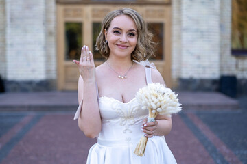 portrait of beautiful young bride in white wedding dress holding bouquet of flowers. wedding day....
