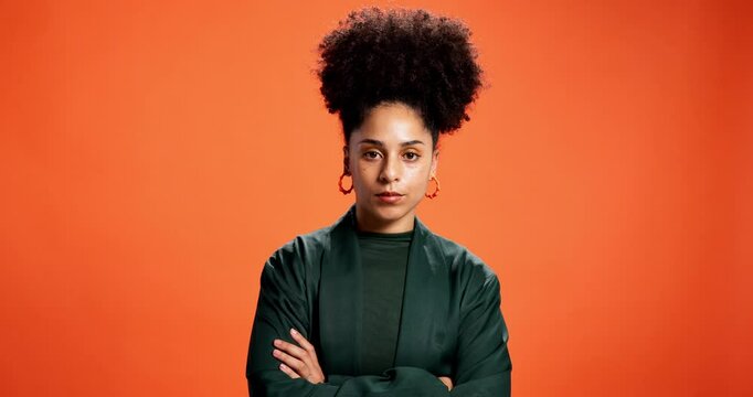 Face, frustrated or woman with arms crossed in studio with defensive body language or attitude. Strict, orange background or upset model disappointed by bad news, space or negative behaviour reaction
