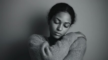 Cinematic portrait of a young woman embracing herself with closed eyes, conveying a sense of comfort, self love, or introspection against a neutral background - Powered by Adobe