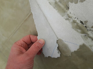 A worker inspects a protective coating on a metal surface made from fiberglass-reinforced...
