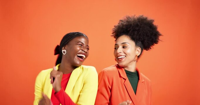 Happy, women or dancing with fashion in studio for celebration, bold aesthetic or party energy. Friends, retro clothes or African people on orange background with rhythm, movement or bonding together