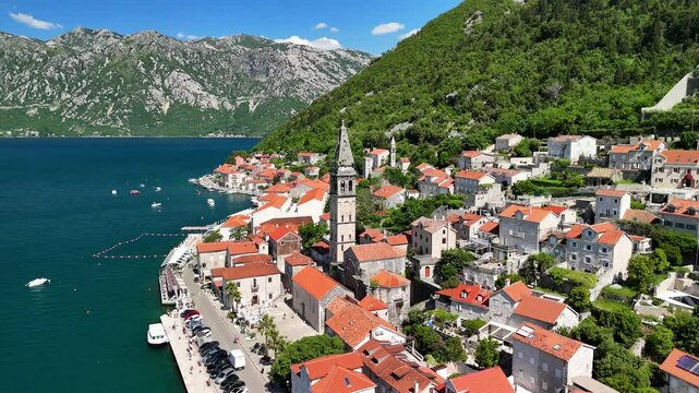 Aerial view of the historic town of Perast, located in the famous Bay of Kotor, on a bright and sunny  day with a blue sky.A drone flies over the picturesque resort town with a rich history.Montenegro
