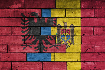 colourful painted big national flag of moldova and flag of albania on a massive old brick wall background. concept