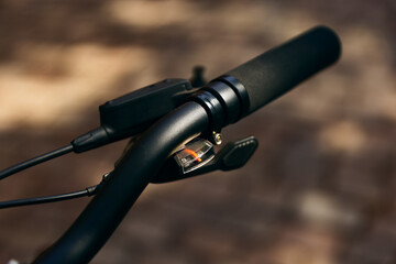 Top view closeup of black modern soft bicycle handle on cobbled street.