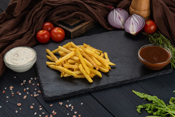 Potatoes on a black background with sauce