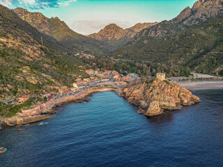 Aerial view town ruins Genoese tower of Porto Corsica France medieval watchtower Mediterranean Sea Calanches de Piana