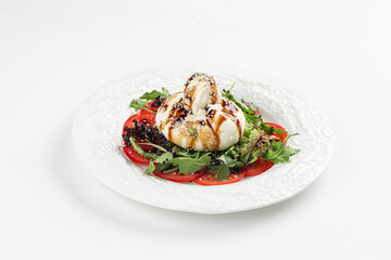 Portion of gourmet burrata salad with tomatoes and arugula