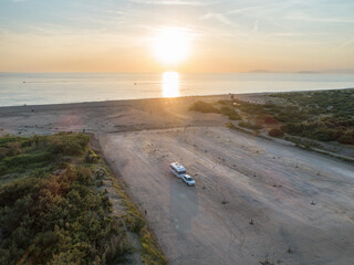 Camper rv caravan on mediterranean coast in Italy. Wild camping on sea shore. Holidays and travel in motor home