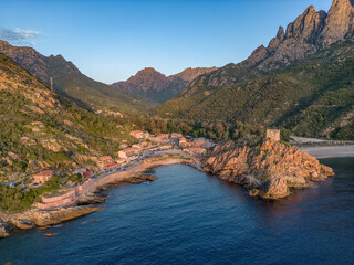 Aerial view town ruins Genoese tower of Porto Corsica France medieval watchtower Mediterranean Sea Calanches de Piana