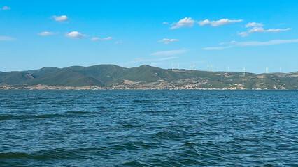 Offshore and onshore windmill park ,Windmill farm green energy at sea, Windmill turbines by the ocean