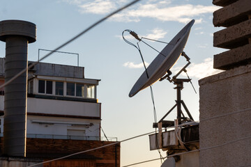 Satellite dish pointing at the sky during sunset on rooftop