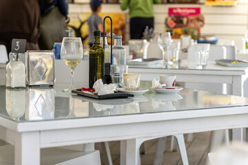 Messy leftover dishes on a white restaurant table with blurred customers ordering food from a waiter or waitress