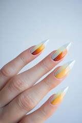 Bold and vibrant nail art: Pointed nails featuring a geometric design in shades of yellow, orange and red, which transition to white tips. Ideal for beauty themes, creativity and expressive manicure t