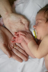 Newborn Baby Holding Parents Hand While Sleeping