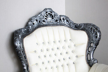 Vintage baroque style soft armchair. Close-up of the back of the soft armchair, armrests with white...