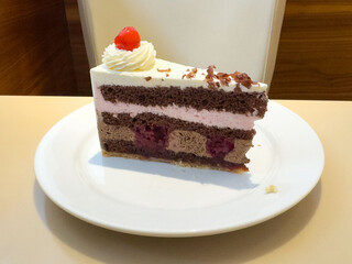Delicious chocolate cherry layer cake with whipped cream garnish on plate