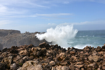 big waves breaking at a cliff in the western Algarve of Portugal