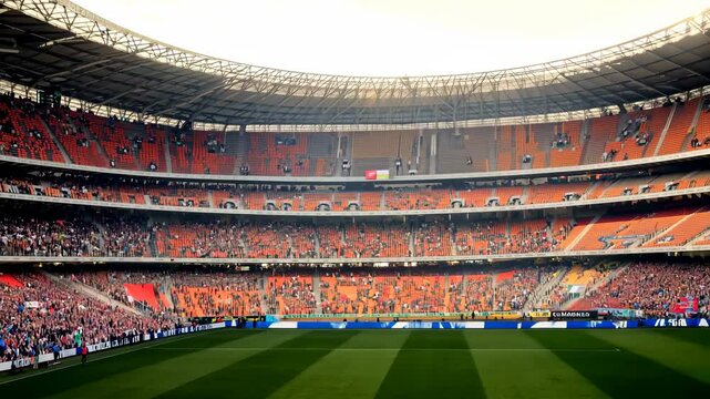 Enthusiastic crowd cheers inside vibrant football stadium during energetic match
