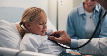 Obraz premium Doctor, child or stethoscope on hospital bed for checkup, visit or examination at healthcare clinic. Girl, kid and medical professional checking patient with tool for heart beat, cardiology or test