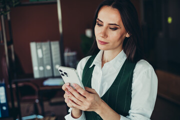 Elegant Businesswoman Using Smartphone in a Modern Office Setting, Engaged and Focused on Work Tasks