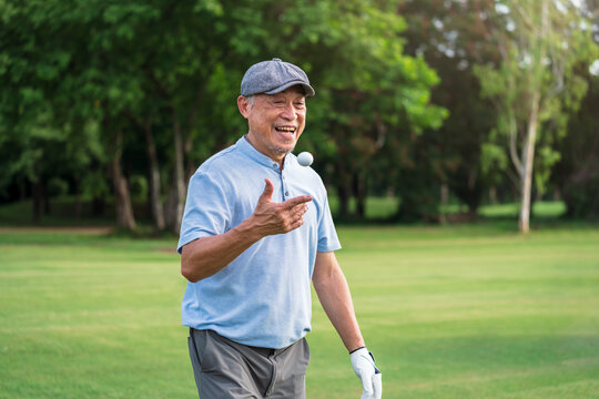 Retirement Lifestyle, Happy Asian senior man golfer walking on green fairway enjoying summer vacation and outdoor golf activity. - Powered by Adobe