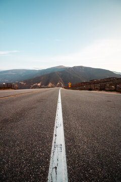 The Open Road: An Empty Desert Highway Stretching Towards the Mountains in the American Southwest
