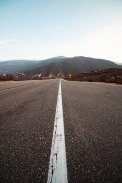 The Open Road: An Empty Desert Highway Stretching Towards the Mountains in the American Southwest
