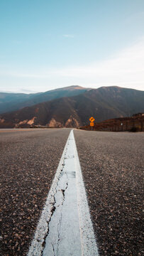 The Open Road: An Empty Desert Highway Stretching Towards the Mountains in the American Southwest