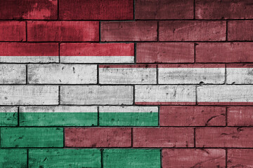 colourful painted big national flag of latvia and flag of hungary on a massive old brick wall background. concept