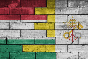 colourful painted big national flag of vatican city and flag of hungary on a massive old brick wall background. concept