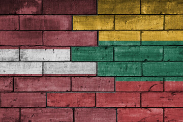 colourful painted big national flag of lithuania and flag of latvia on a massive old brick wall background. concept