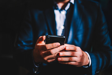 Business man with mobile phone in hands, close up view. Businessman in suit holding cell phone