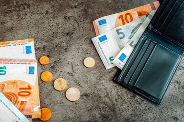 Finance. Money banknotes, coins and black wallet. Euros on dark background
