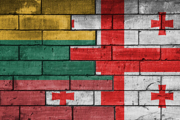 colourful painted big national flag of georgia and flag of lithuania on a massive old brick wall background. concept