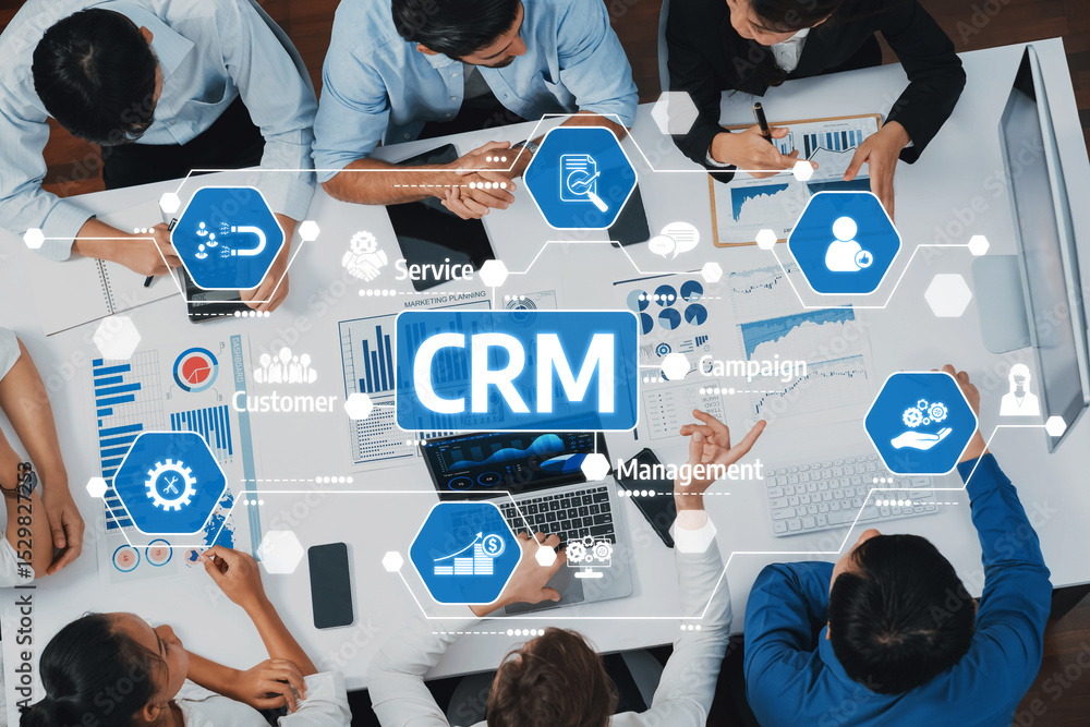 Poster Diverse business team engaged in collaborative CRM strategy discussion with data-driven visuals and charts in a modern office setting. Focus on teamwork and productivity. Amity