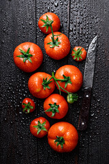 Top view of ripe red tomatoes covered with water drops on rustic table. Food photography