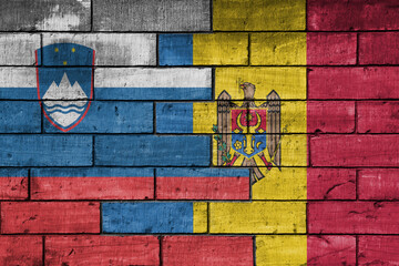colourful painted big national flag of moldova and flag of slovenia on a massive old brick wall background. concept