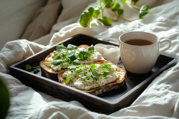 Freshly made creative toasts topped with various ingredients are presented on a wooden tray next to a steaming cup of tea, enhancing a relaxed morning atmosphere