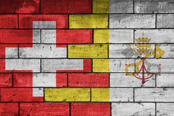 colourful painted big national flag of vatican city and flag of switzerland on a massive old brick wall background. concept