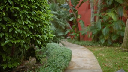 Blurred pathway surrounded by lush tropical greenery leading to an exotic luxury resort, evoking tranquility and escape in a serene outdoor setting.